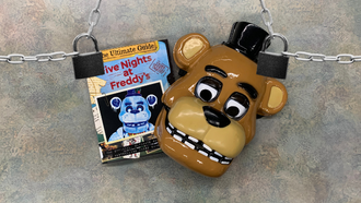 Photo of a Freddy mask and book with two locks dangling from chains.